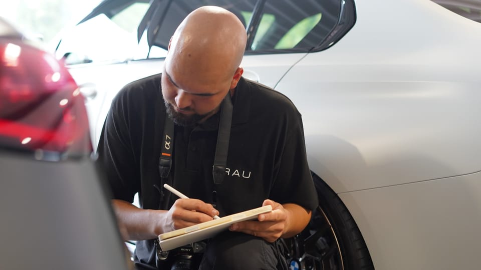 TRAU-Gutachter erfasst einen Unfallschaden am Fahrzeug auf dem Tablet